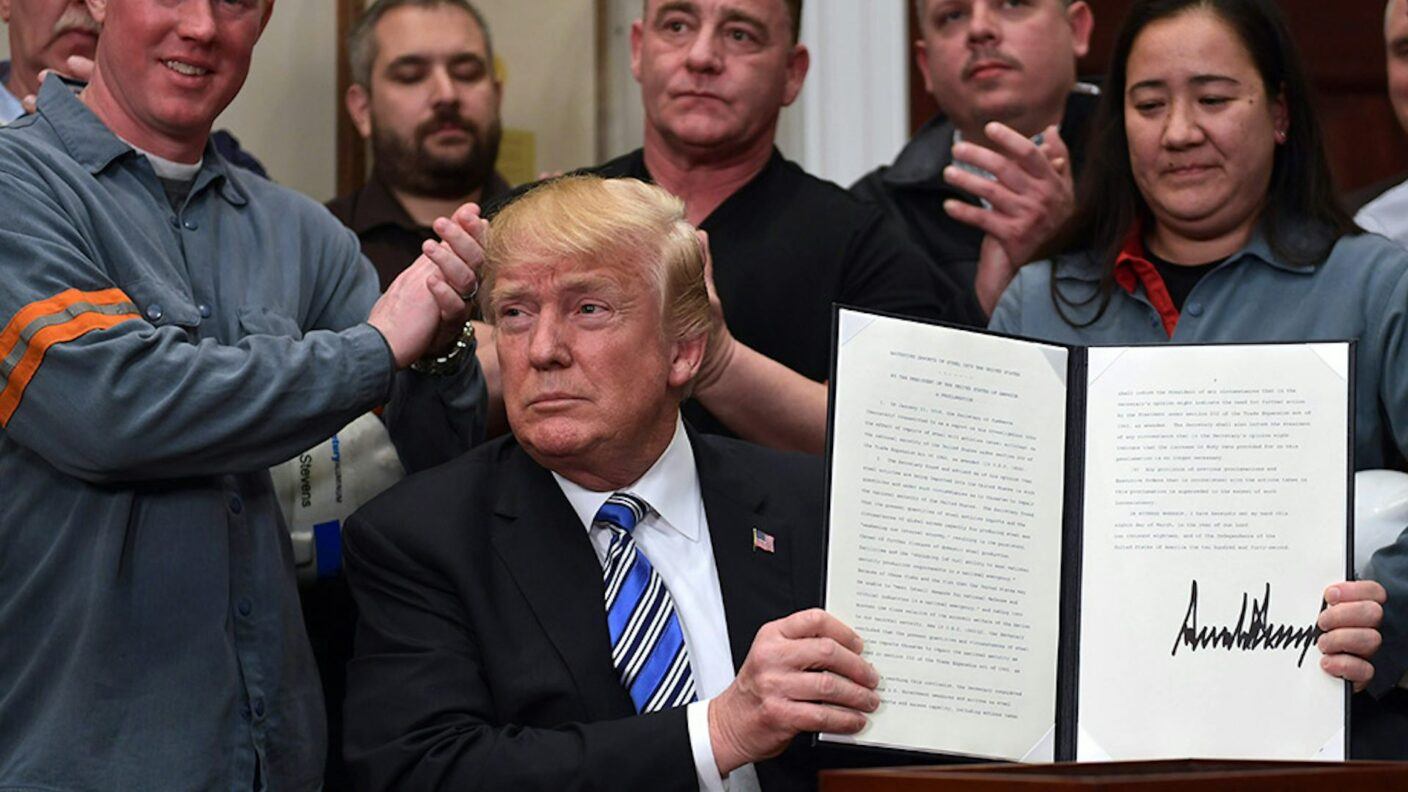 Donald Trump holding up his proclamation on steel imports