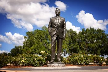 A statue of George H.W. Bush between the Bush School and the Bush Library. (Texas A&M Marketing & Communications)