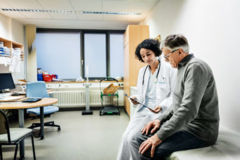 An elderly man talks to his doctor.