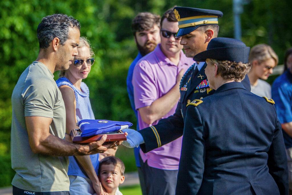 A flag is presented to George P. Bush at President George H.W. Bush and First Lady Barbara Bush's grave site.