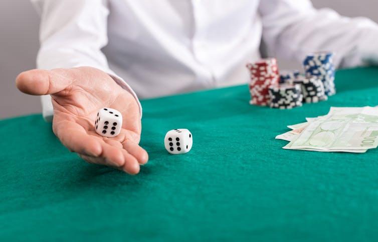 Person rolling two six-sided dice