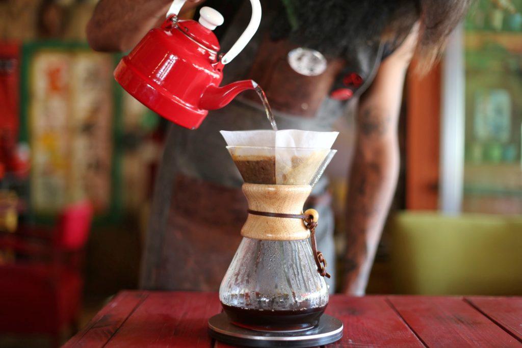 Midsection Of Woman Pouring Coffee On Table