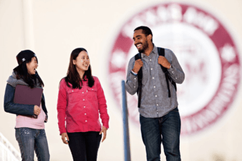 3 students in front of the Texas A&M University seal