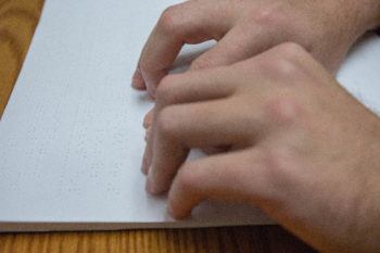 hands move over braille text