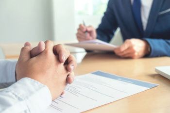 Executive reading a resume during a job interview and businessman Completing Application Form.