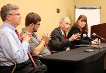 Panelists at a table discussing impeachment