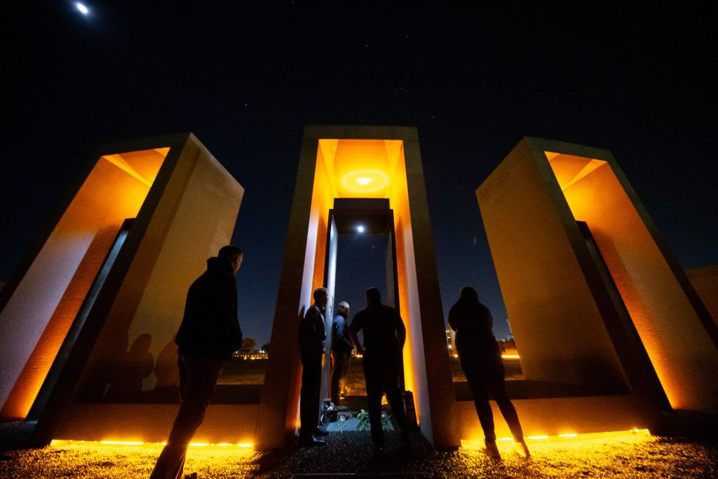 visitors to the bonfire memorial silhoutted against the portals