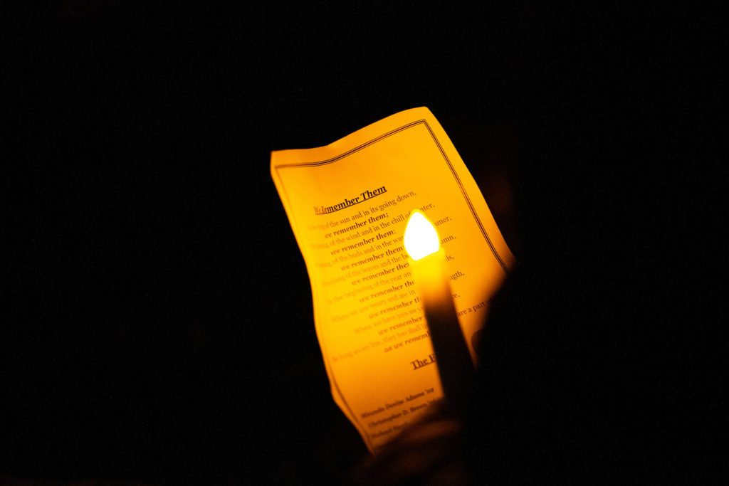 lit candle in front of a program at the bonfire remembrance ceremony