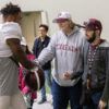 Aggie achieve students at a Texas A&M practice facility with Jimbo Fisher meeting with a football player