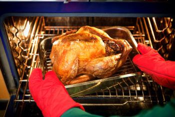 Freshly roasted turkey with stuffing coming out of the oven.