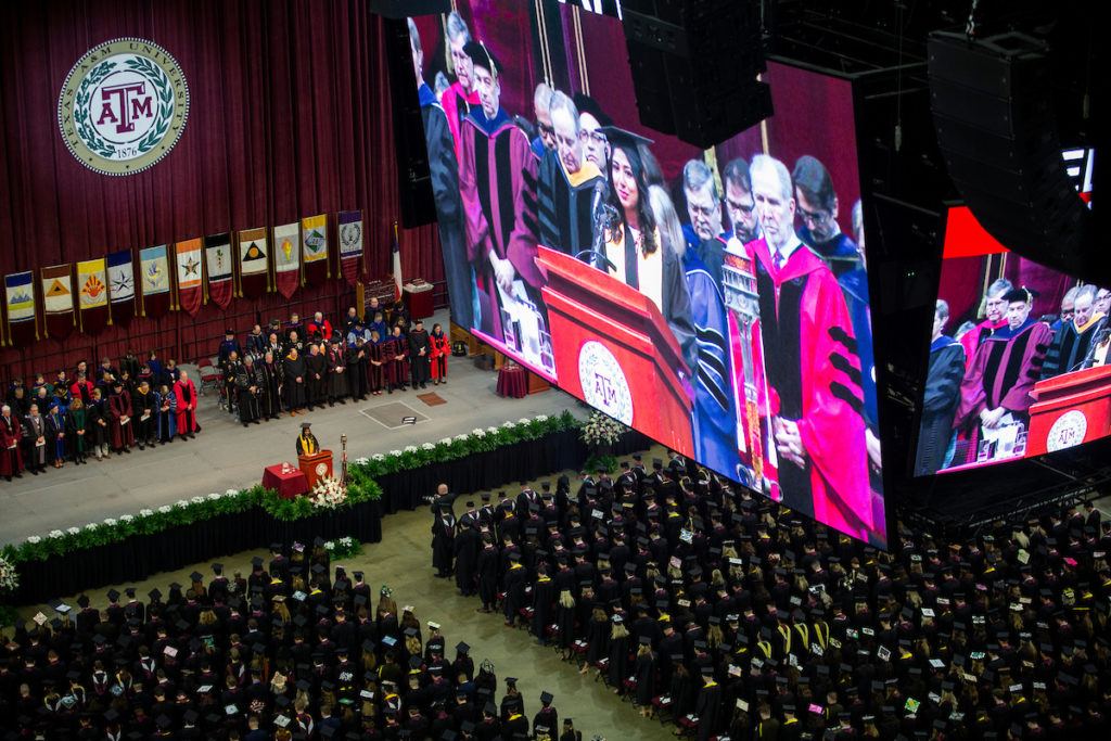 the jumbotron in reed arena showing a graduation speech above the graduates