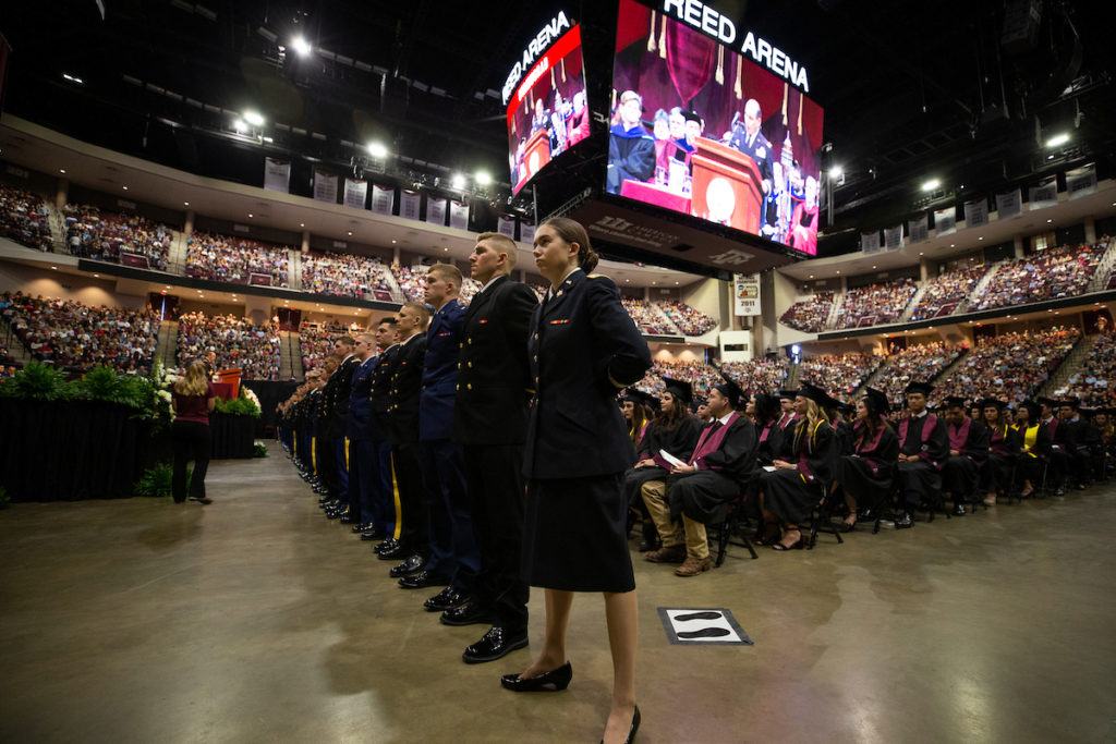 cadets stand in a line in reed arena at the front of the graduation ceremony