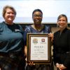 Jennifer Reyes, Robin Means-Coleman and Holly Mendelson pose with the framed Diversity Champion Award