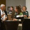 Two event attendees talking to one another at a table.