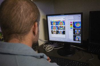 A man looks at images on a computer screen