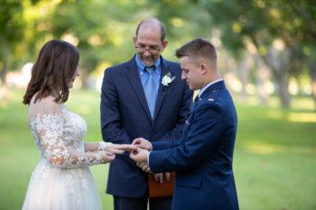 a professor standing between a bride and a groom at a wedding