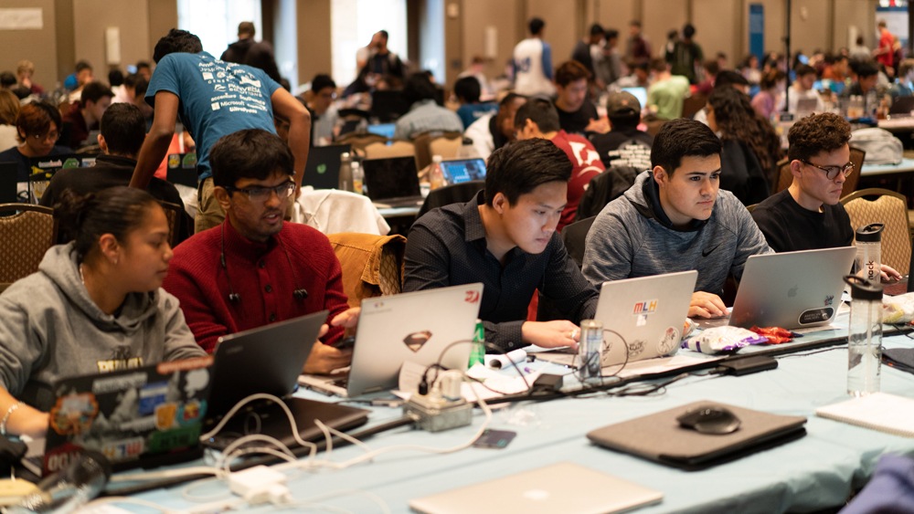 rows of students sitting in front of laptops