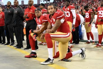 football players kneeling on the sidelines