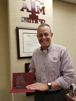col. gerald smith stands with his award