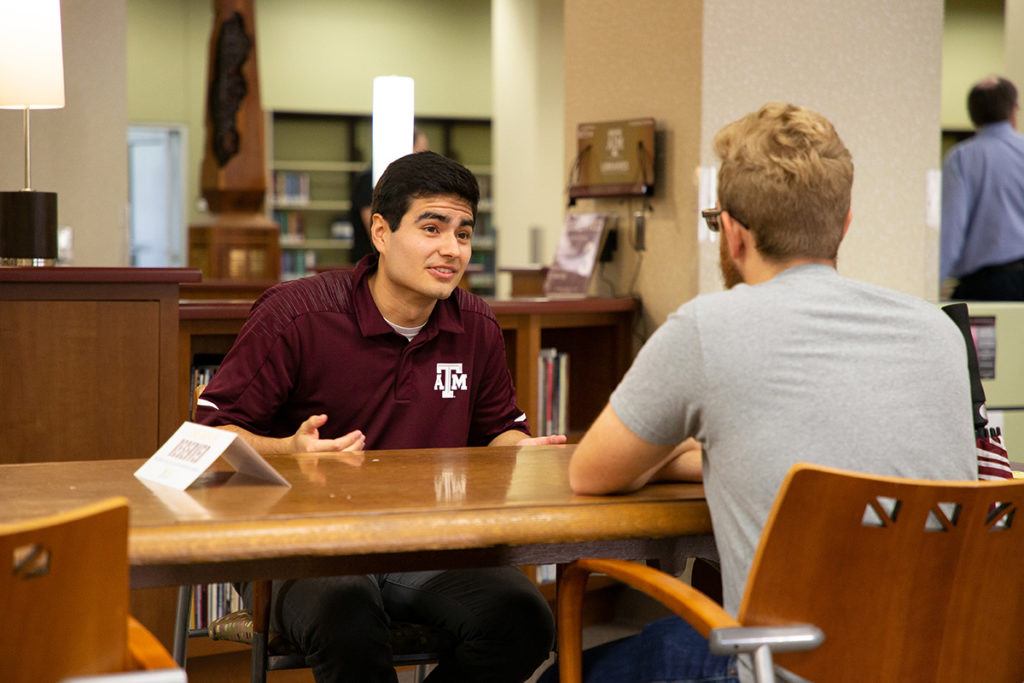 Two men sit across from each other and talk at the Human Library