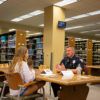 A woman sitting across from a University Police Officer having a conversation.