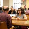 A man and woman sitting across a table from one another having a conversation