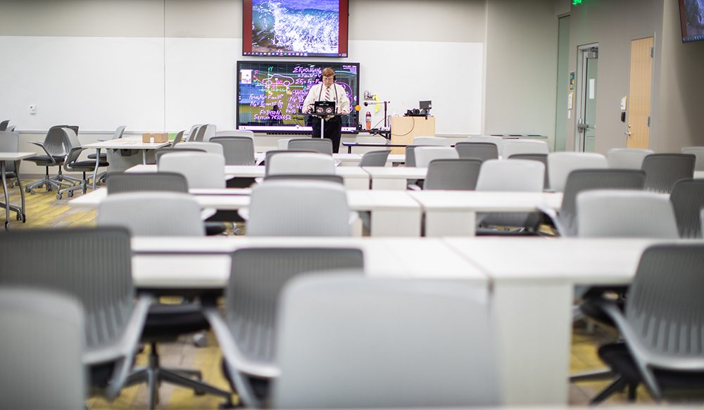 professor teaching in front of an empty classroom