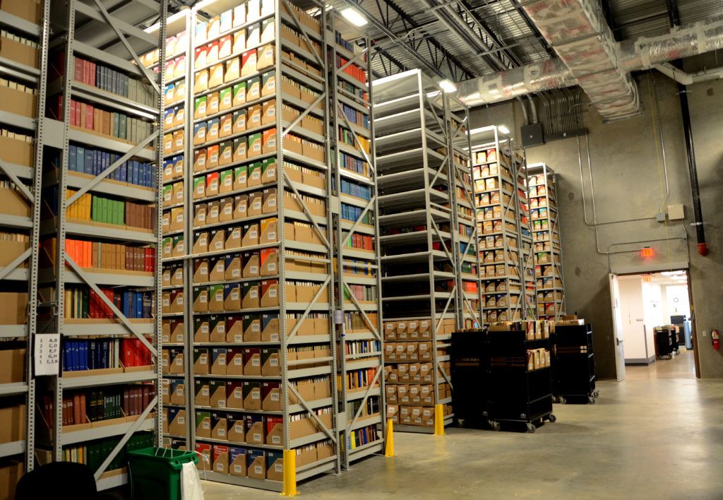 a warehouse filled with tall shelves of manuscripts and books