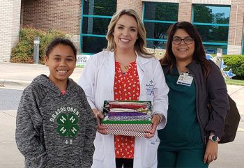 a photo of a young volunteer posing with health care workers