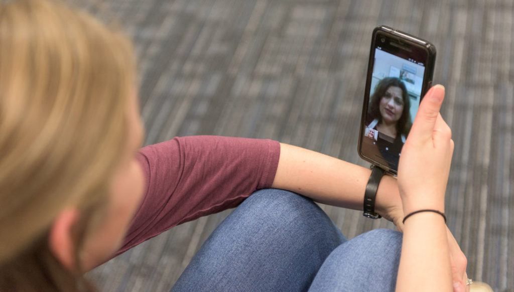 a woman looks at a doctor on her phone screen