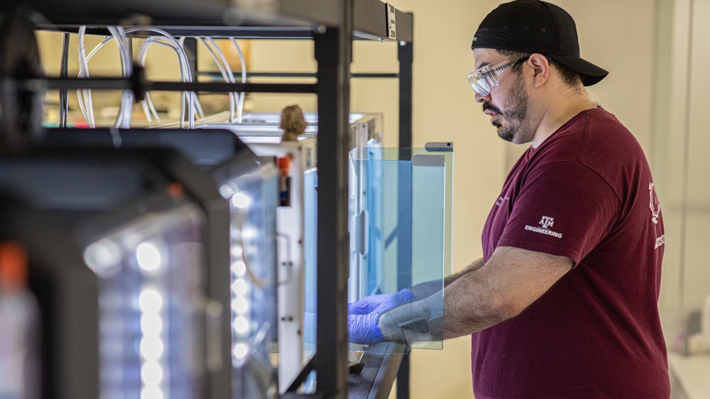 a technician in a lab works at a 3D printer