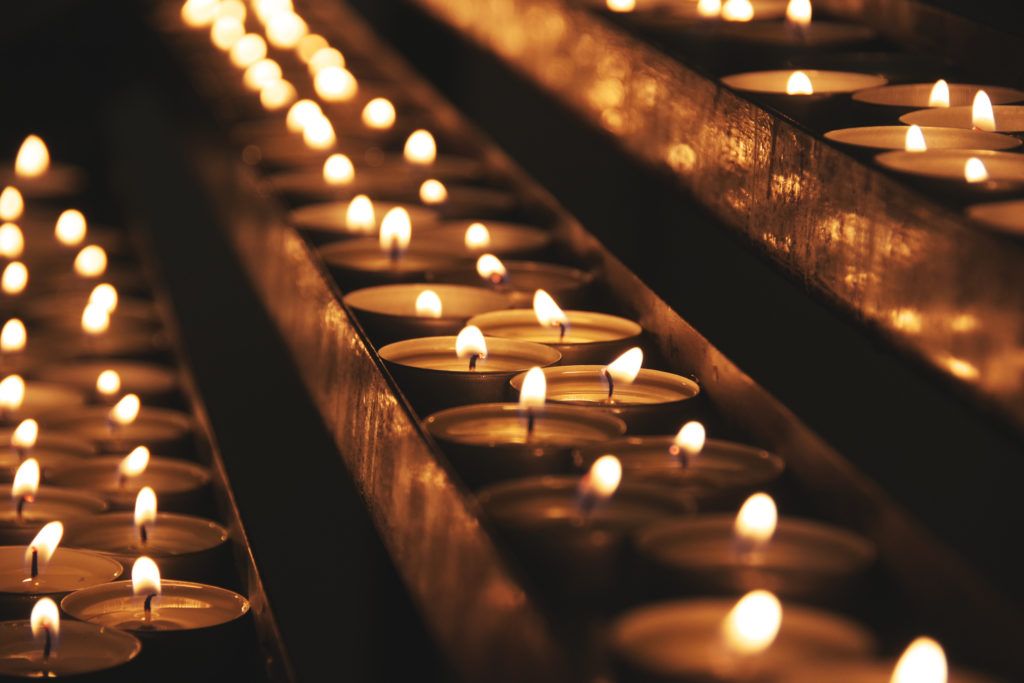 a group of lit votive candels