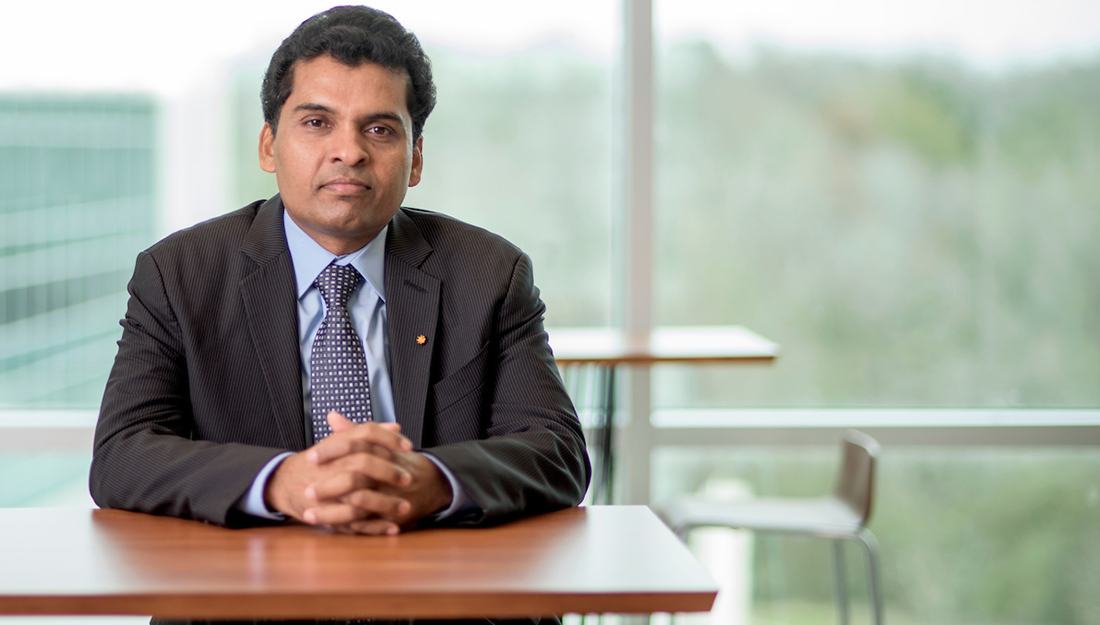 portrait of samba reddy sitting at a desk with arms crossed