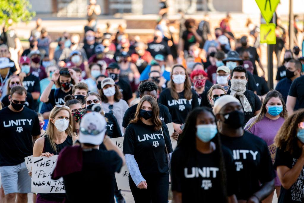hundreds of people marching with unity t shirts