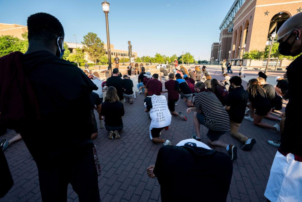 students kneeling near kyle field