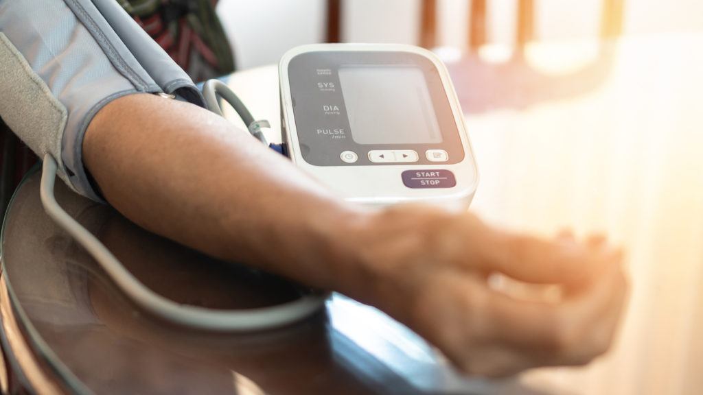 patient with blood pressure monitor on arm