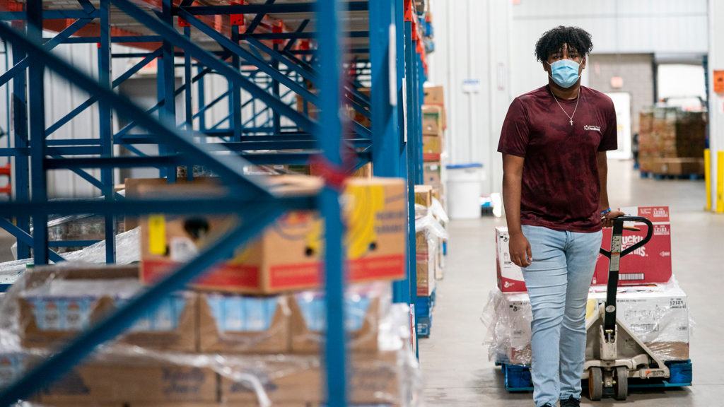 a man hauling a pallet at the food bank