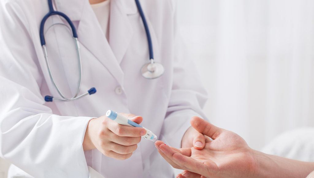 close up image of doctor measuring a patient's blood sugar