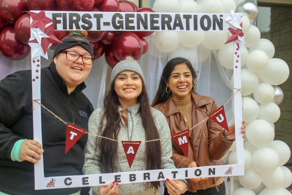 three students pose inside a frame that says first generation celebration