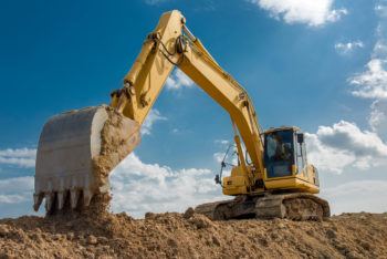 excavator on construction site in front of blue sky