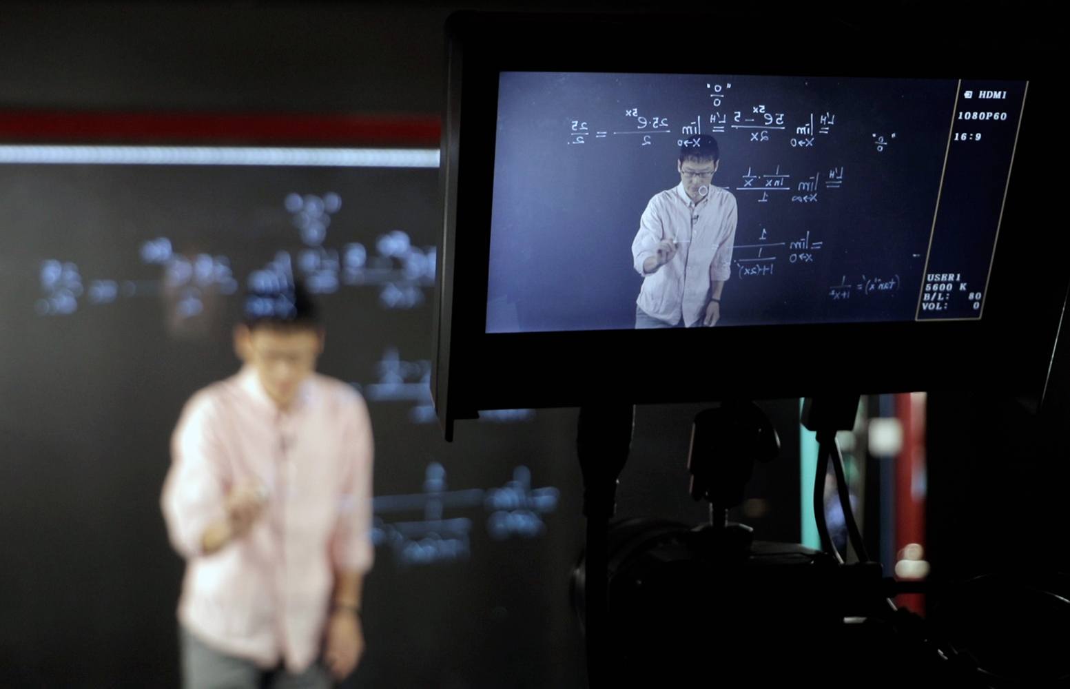 a camera's viewfinder focused on a mathemetician in front of a blackboard covered in equations
