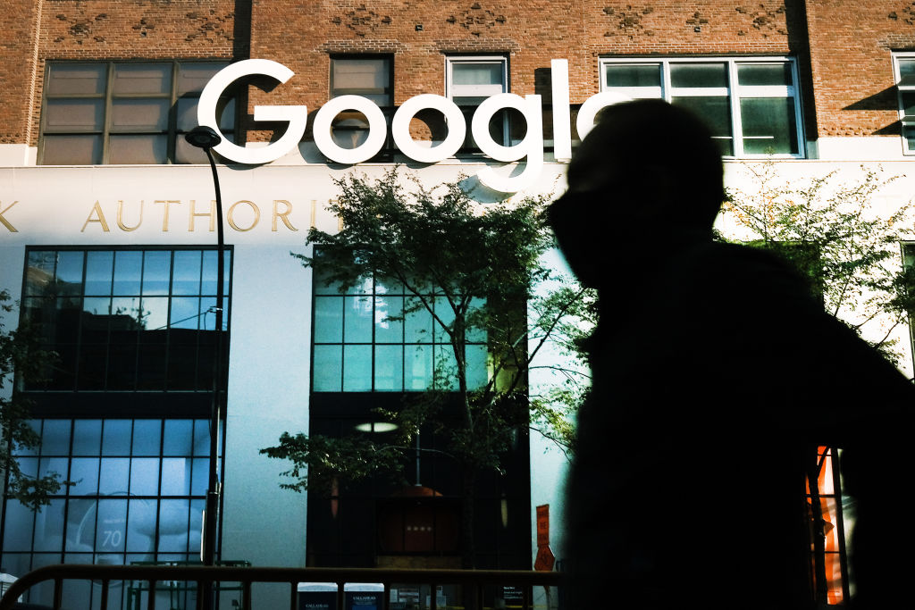 man in shadow walks by the office of google in new york city