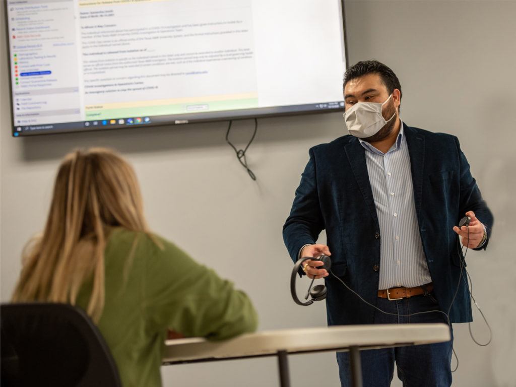 a photo of Oscar Hernandez, Jr. instructing students at the COVID-19 operations center