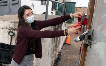 The 12th Can food pantry's director Kelly Villarreal cutting the ribbon on the new freezer trailer