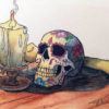 a drawing of a sugar skull on a table next to a candle and a human bone