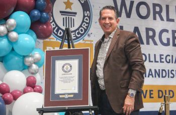 a photo of C.C. Creations owner Kenny Lawson posing with the store's world record certificate