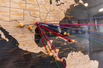 a map of north and south america with pushpins and strings connecting to countries where clinics have been deployed
