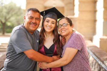 Lizeth Parra wearing a cap and gown posing with her parents