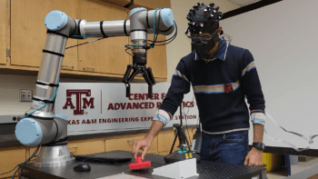 researcher in the lab next to a robotic arm