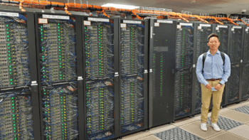 man standing next to a super computer